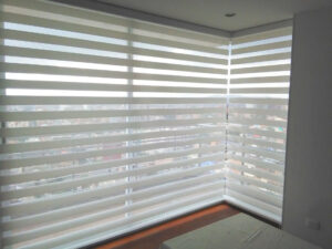 Cortina Sheer Elegance Screen color Blanco de Comaldec en Sala con Ventana en ángulo